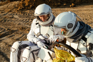 Two astronauts training with equipment on a simulated Mars surface, similar to mission simulations at the US Space Academy