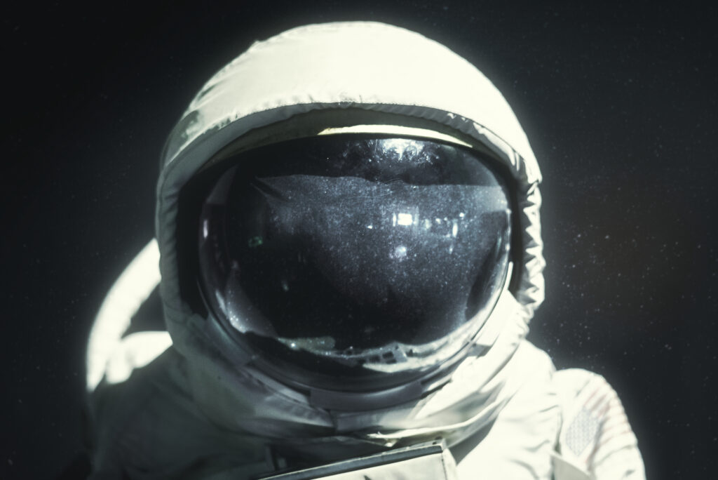 Close-up of a spacesuit helmet visor reflecting light, representing the engineering behind spacesuit design